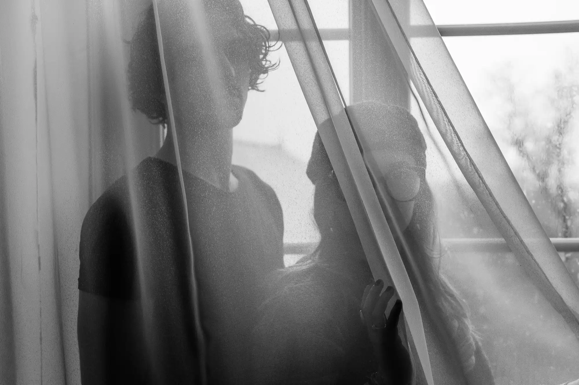 Photo de couple en noir et blanc derrière un voile