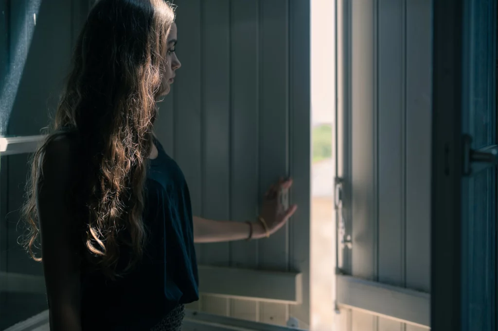 Photo de jeune femme à la fenêtre.