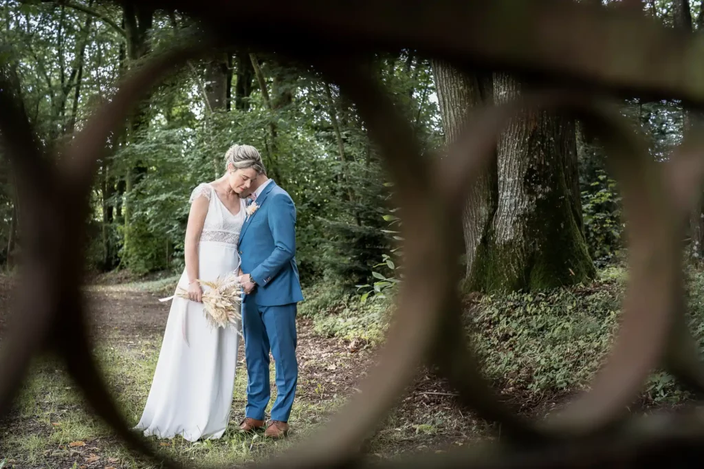 Mariés émus se tenant la main et fermant les yeux lors d'un first look intime.