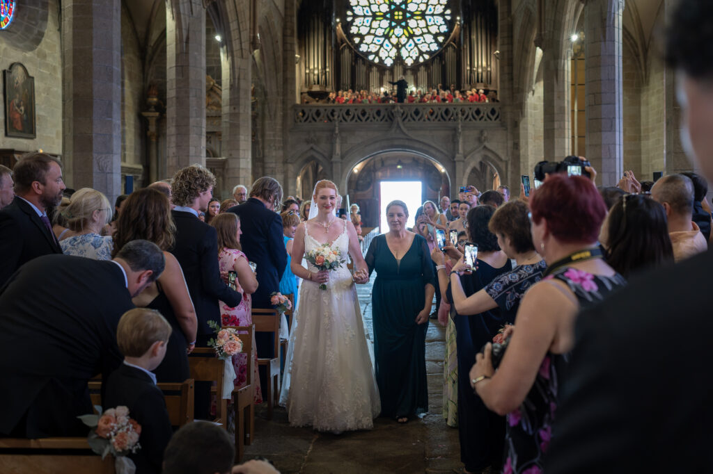 Mariée dans l'allée de l'église sous le regard de son futur mari.